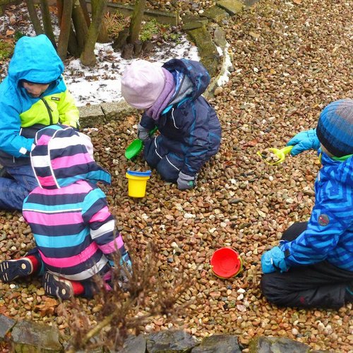 Kinder spielen mit Eimern und Schaufeln