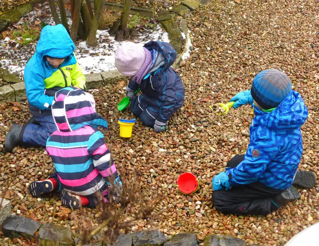 Kinder spielen mit Eimern und Schaufeln